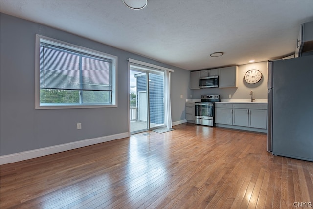 kitchen featuring sink, gray cabinets, hardwood / wood-style floors, and stainless steel appliances