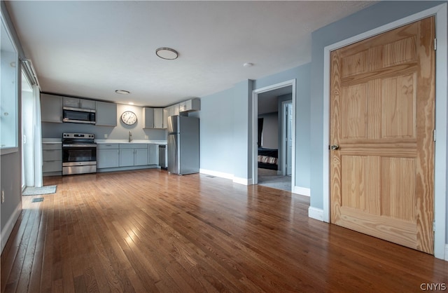 unfurnished living room featuring sink and wood-type flooring