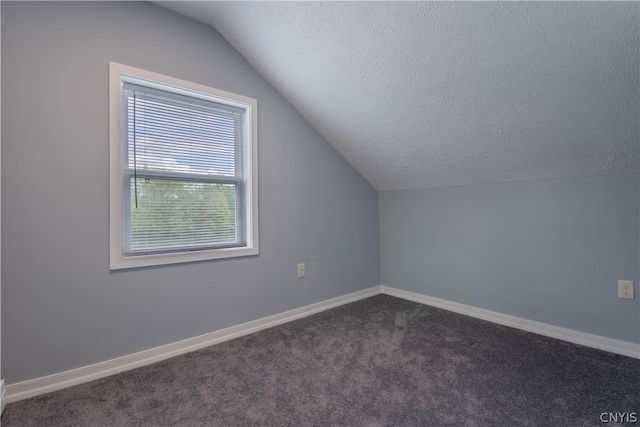 bonus room featuring dark carpet, a textured ceiling, and lofted ceiling