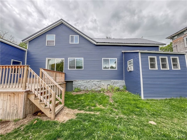 rear view of house with a deck and a lawn