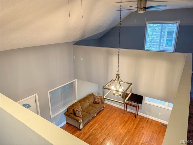 interior space with hardwood / wood-style flooring and ceiling fan with notable chandelier