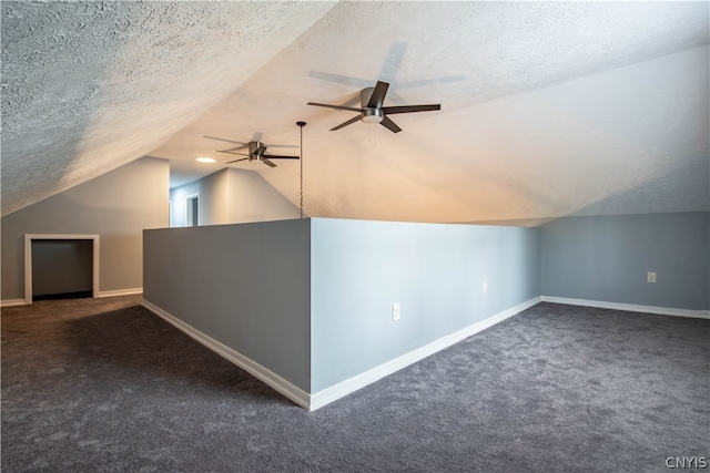 additional living space with ceiling fan, vaulted ceiling, a textured ceiling, and dark carpet