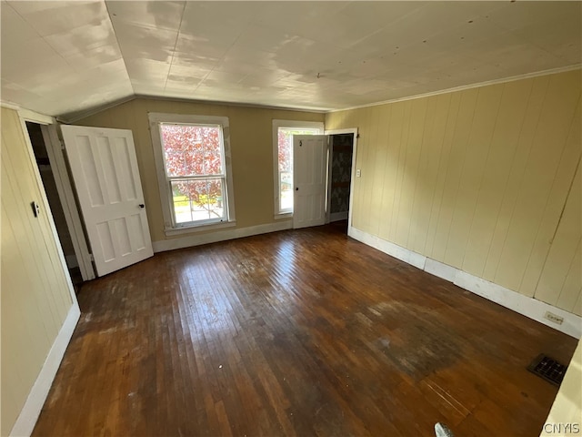 spare room featuring vaulted ceiling, dark hardwood / wood-style flooring, and ornamental molding