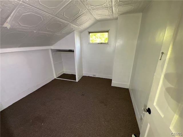 spacious closet with dark carpet and lofted ceiling