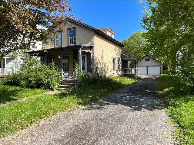 view of front facade with a garage, covered porch, and an outdoor structure