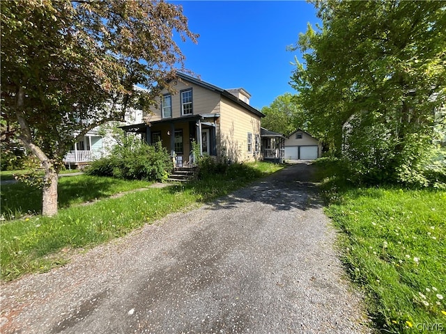 view of front of property with a garage, an outdoor structure, and a porch