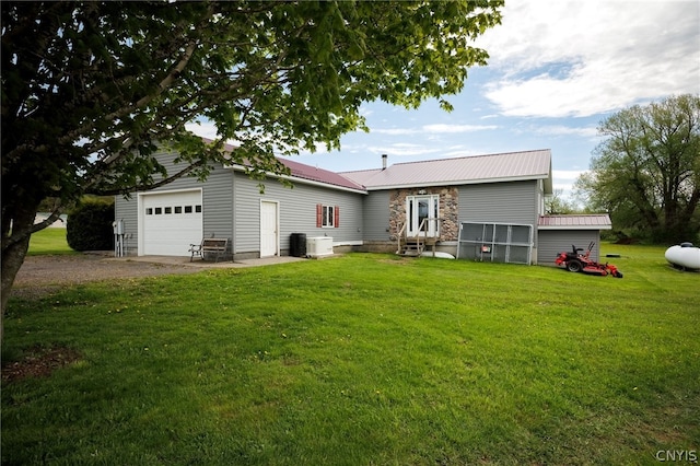 back of property featuring a yard and a garage