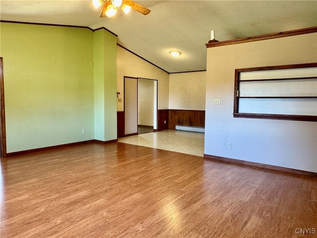 empty room with light hardwood / wood-style floors, a textured ceiling, a baseboard radiator, ornamental molding, and ceiling fan