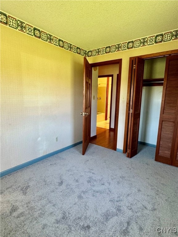 unfurnished bedroom with a closet, carpet, and a textured ceiling