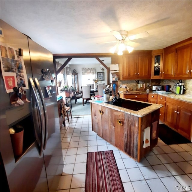 kitchen with stainless steel fridge, black electric stovetop, ceiling fan, and light tile patterned floors