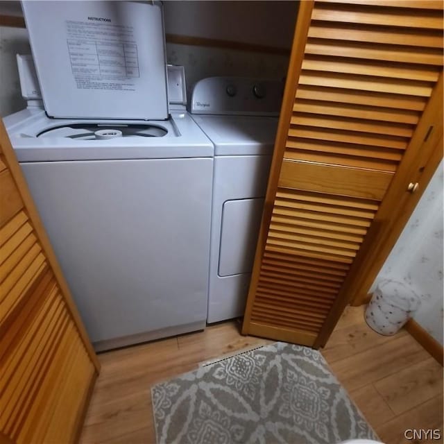 washroom with laundry area, light wood-style flooring, and washer and clothes dryer
