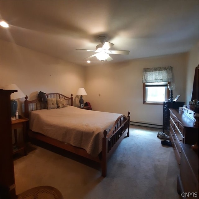 carpeted bedroom featuring a baseboard heating unit and ceiling fan