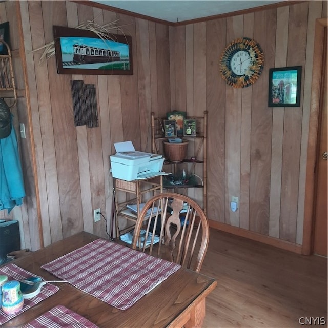 dining room with light hardwood / wood-style flooring and wooden walls