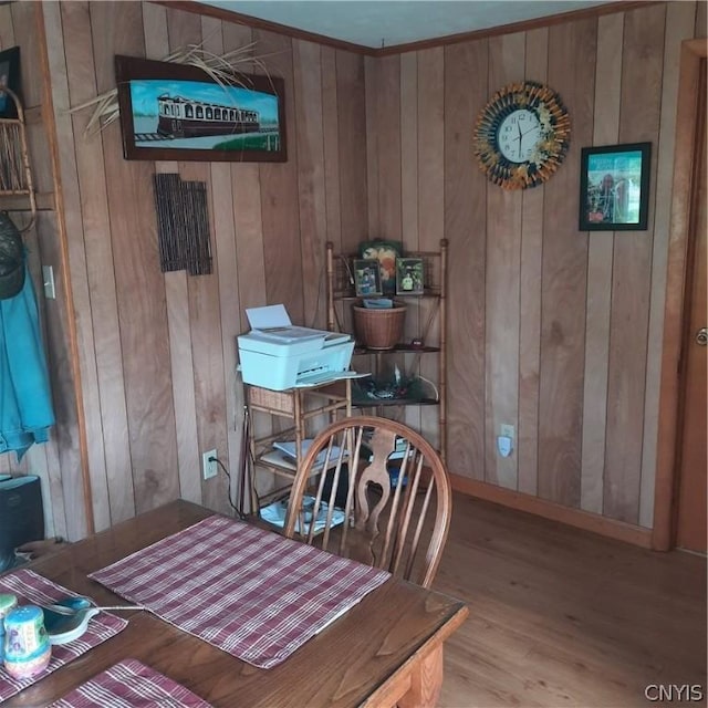dining room featuring wood walls and wood finished floors