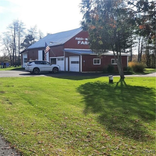 view of yard featuring driveway and a garage