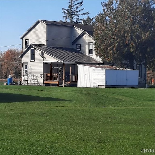 rear view of house featuring a yard