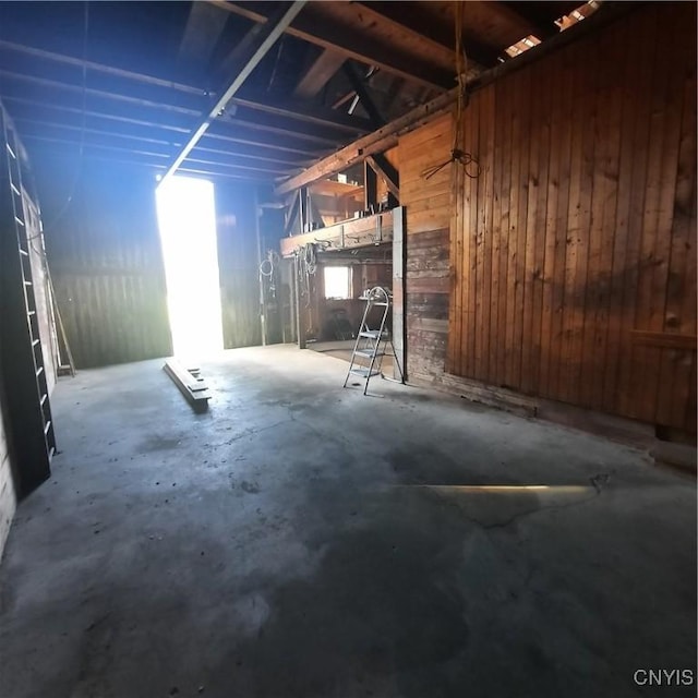 basement with wood walls and a garage