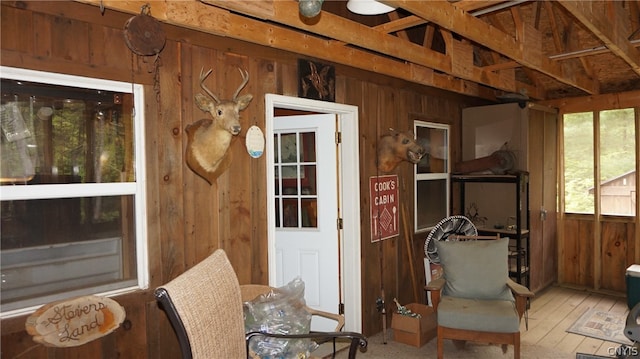 sitting room with wooden walls and light wood-type flooring