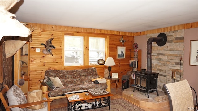 living room with wood walls, hardwood / wood-style floors, and a wood stove