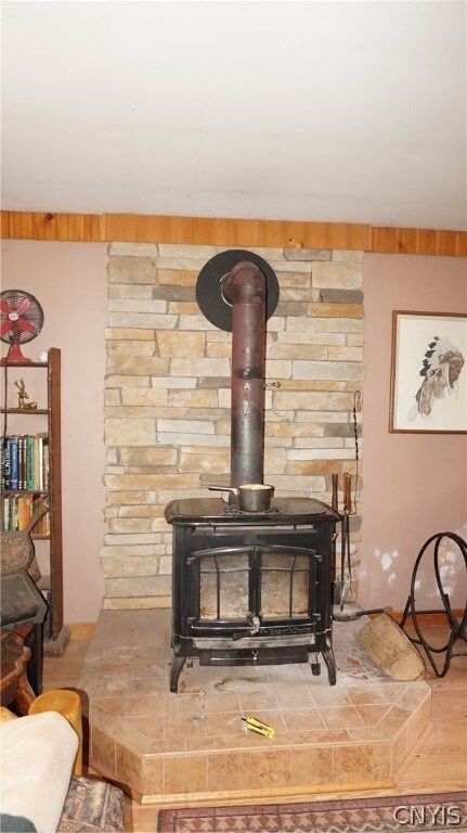 details with hardwood / wood-style flooring and a wood stove