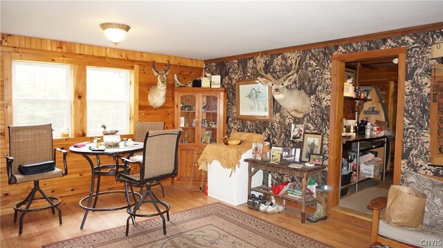 dining space featuring wood-type flooring and wood walls