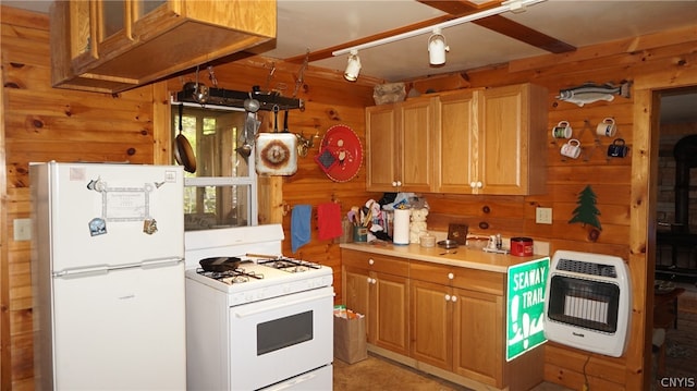 kitchen featuring a wood stove, wooden walls, and white appliances