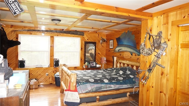 bedroom featuring coffered ceiling, wooden walls, beamed ceiling, and light wood-type flooring