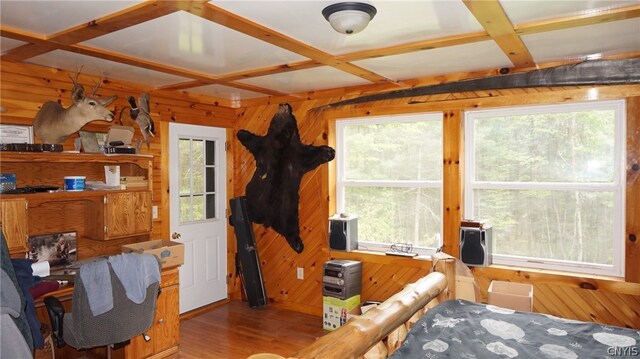 interior space with wood-type flooring, wood walls, coffered ceiling, and multiple windows