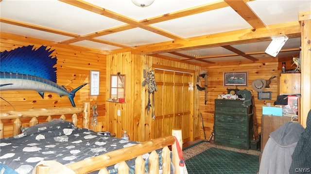 bedroom featuring beam ceiling, coffered ceiling, and wood walls