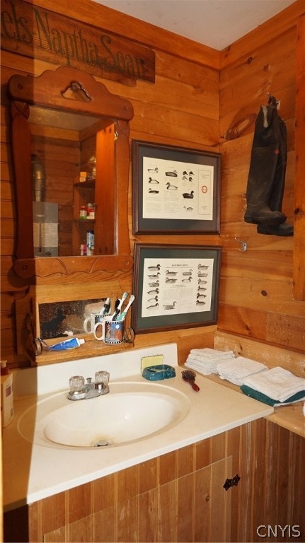 bathroom with wood walls and sink