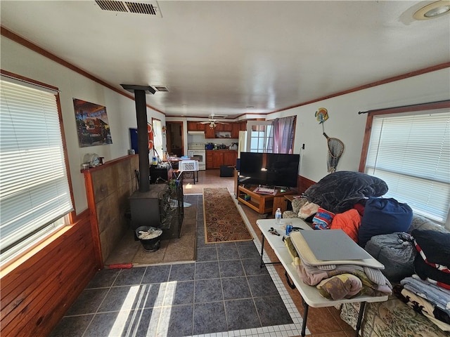 living room featuring crown molding, dark tile flooring, and ceiling fan