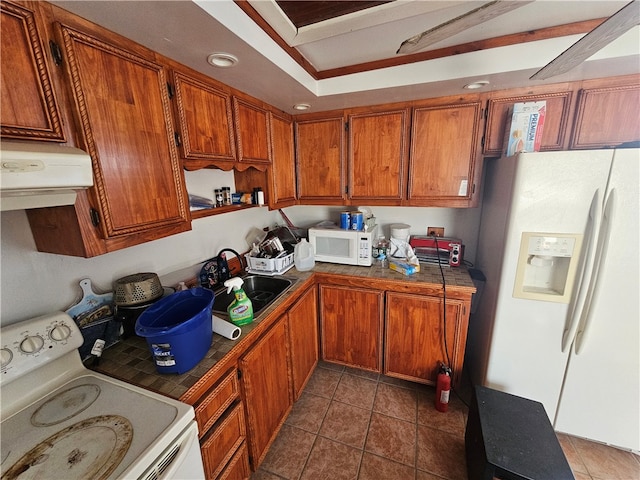 kitchen featuring white appliances, sink, and dark tile floors