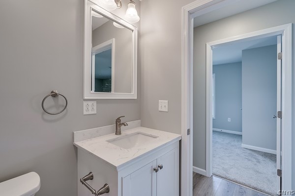 bathroom with hardwood / wood-style flooring, toilet, and large vanity