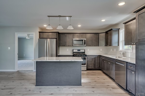 22217 Freedom Dr, Champion, NY 13619 - kitchen with appliances with stainless steel finishes, sink, light hardwood / wood-style flooring, and a kitchen island