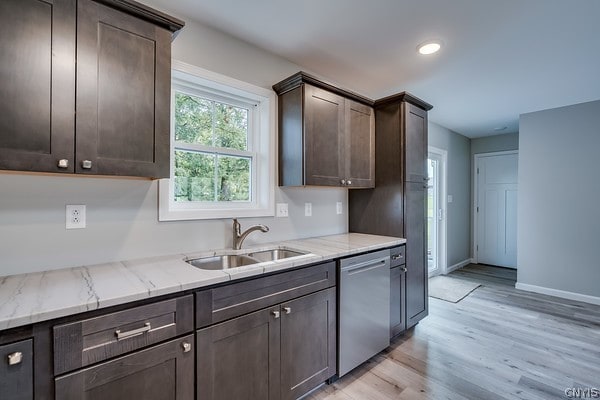 kitchen featuring dark brown cabinetry, dishwasher, light stone countertops, light wood-type flooring, and sink