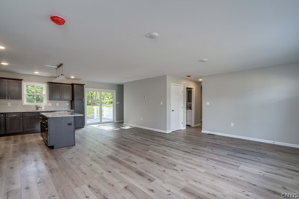 22217 Freedom Dr, Champion, NY 13619 - kitchen with a center island, sink, dark brown cabinets, and light wood-type flooring