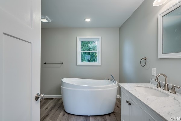22217 Freedom Dr, Champion, NY 13619 - bathroom featuring hardwood / wood-style flooring, a washtub, and vanity with extensive cabinet space
