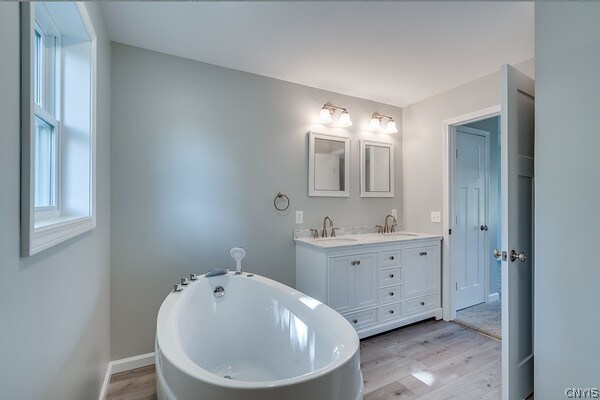 22217 Freedom Dr, Champion, NY 13619 - bathroom with a bath, double vanity, and hardwood / wood-style flooring