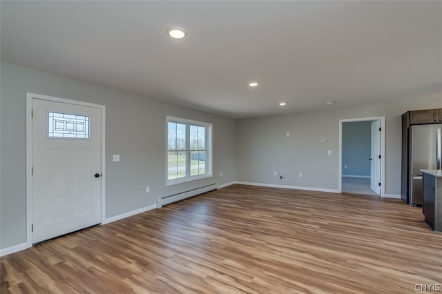 22217 Freedom Dr, Champion, NY 13619 - unfurnished living room featuring a baseboard radiator and light wood-type flooring
