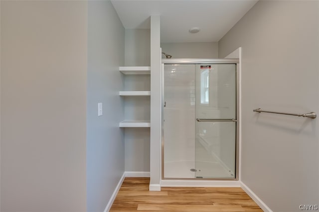 bathroom featuring walk in shower and hardwood / wood-style flooring