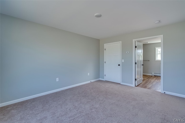 unfurnished bedroom with carpet flooring and a baseboard radiator