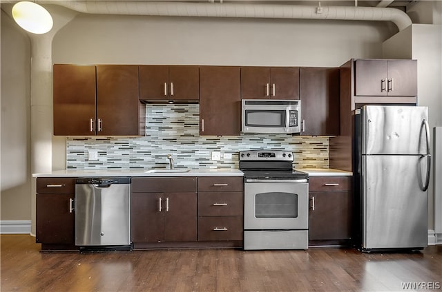 kitchen featuring dark hardwood / wood-style flooring, tasteful backsplash, dark brown cabinets, and stainless steel appliances