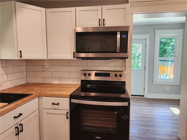 kitchen with hardwood / wood-style floors, tasteful backsplash, stainless steel appliances, wood counters, and white cabinets