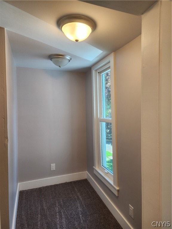 empty room with a healthy amount of sunlight and dark carpet