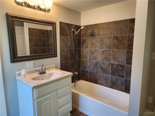 bathroom with tiled shower / bath and vanity