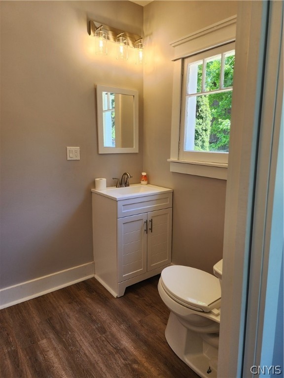 bathroom with hardwood / wood-style floors, vanity, and toilet