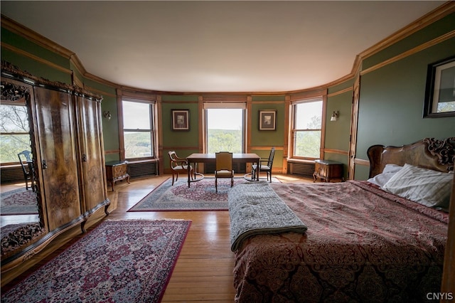 bedroom with crown molding and light wood-type flooring