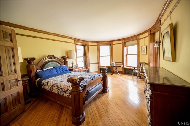 bedroom featuring ornamental molding and light wood-type flooring