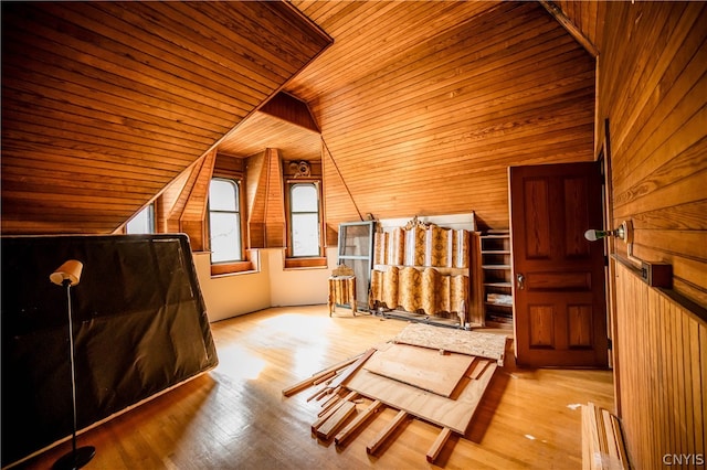 bonus room with vaulted ceiling, wooden ceiling, light hardwood / wood-style flooring, and wooden walls