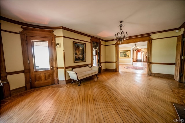 interior space featuring crown molding, a chandelier, and light wood-type flooring